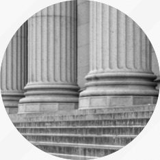 A black and white photo of columns in a circle.